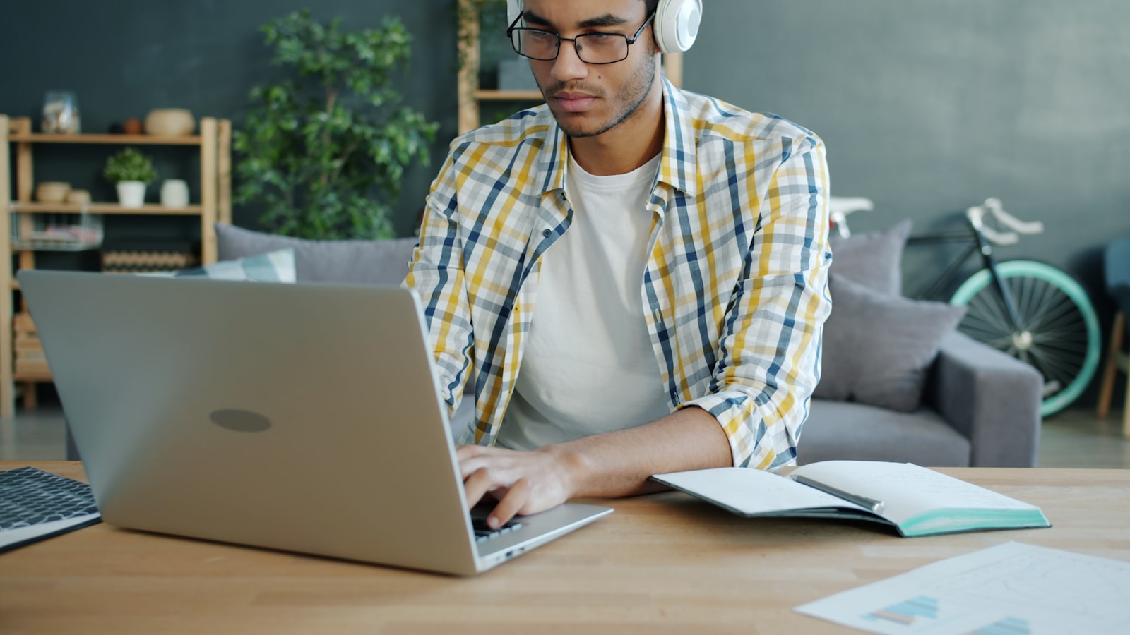 A learner wearing headphones and studying at a laptop